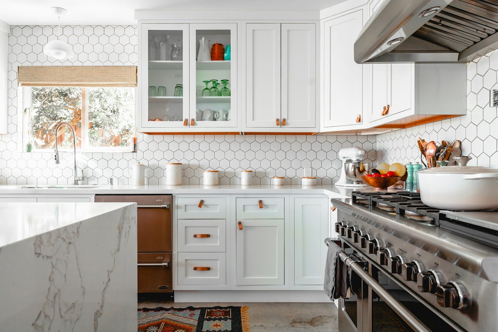 Renovated kitchen with white cabinetry and a marble island